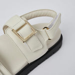 White Barna leather sandals angled view with gold buckles